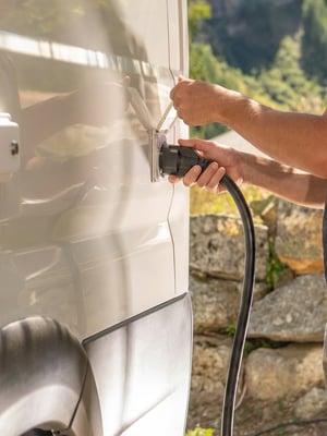 a man plugging his rv into a shore power hookup